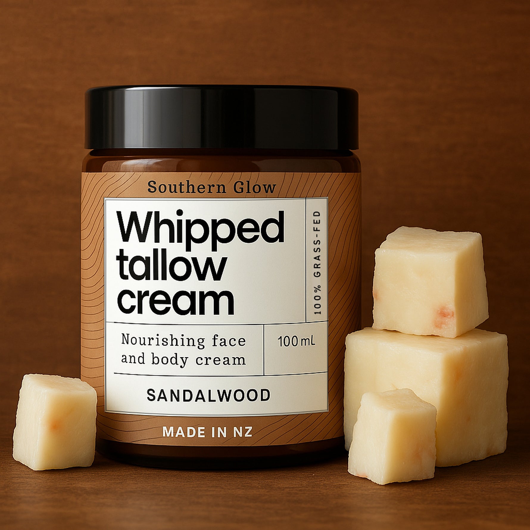 Jar of whipped tallow cream with sandalwood scent, surrounded by cream cubes on a wooden surface.